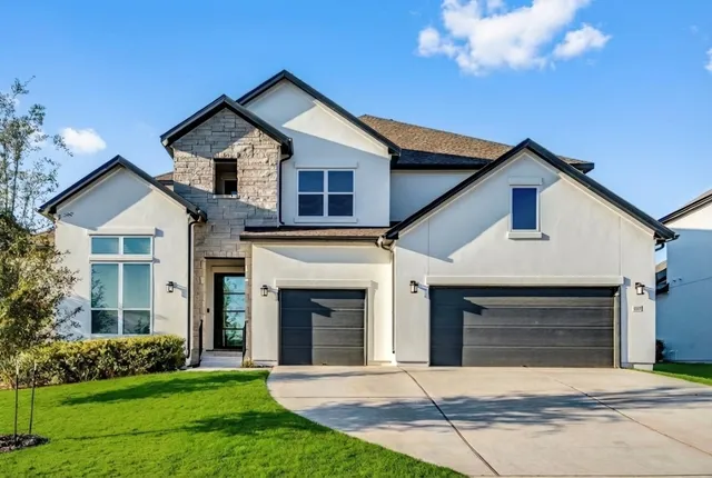 a front view of a house with a garden and yard