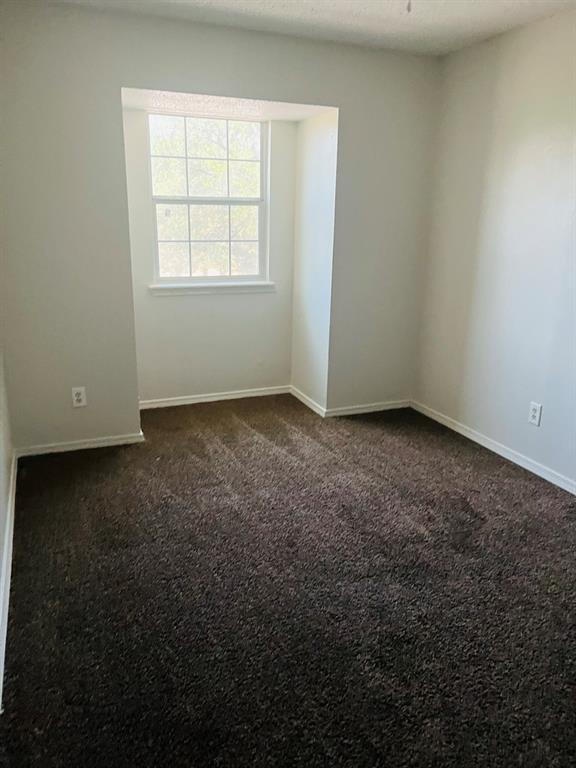 6320 Midway Road, Unit B Springtown, TX 76082 - Photo 15 of 19 Empty room with dark carpet and a textured ceiling
