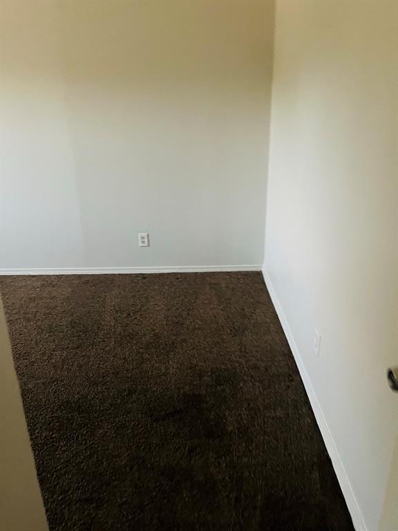 6320 Midway Road, Unit B Springtown, TX 76082 - Photo 16 of 19 Empty room featuring dark colored carpet and baseboards