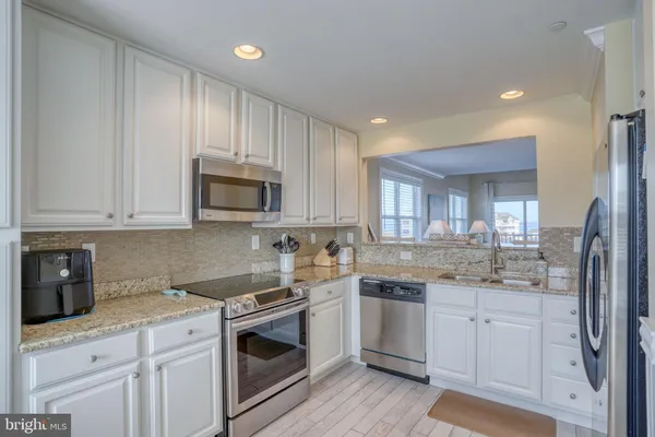 a kitchen with stainless steel appliances kitchen island granite countertop a stove a sink and a microwave