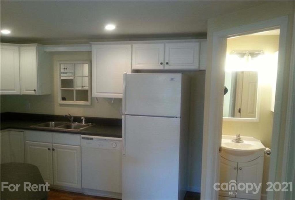 385 James Street Clyde, NC 28721 - Photo 4 of 14 a kitchen with a refrigerator and a sink