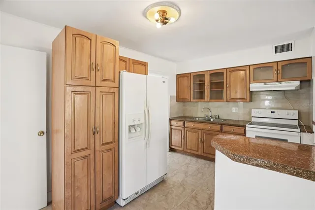a kitchen with stainless steel appliances granite countertop a refrigerator and a sink