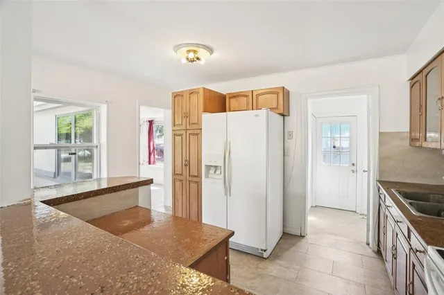 a kitchen with stainless steel appliances granite countertop a refrigerator and a sink