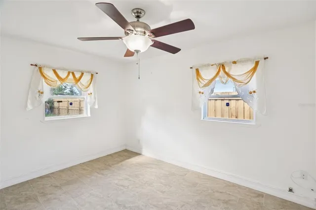an empty room with a window and a ceiling fan