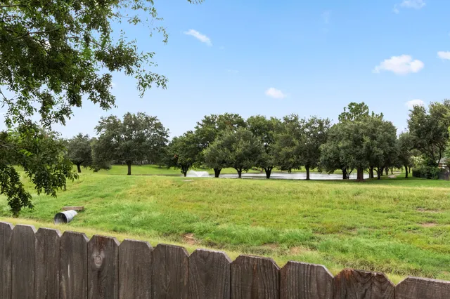 a view of a house with backyard and trees