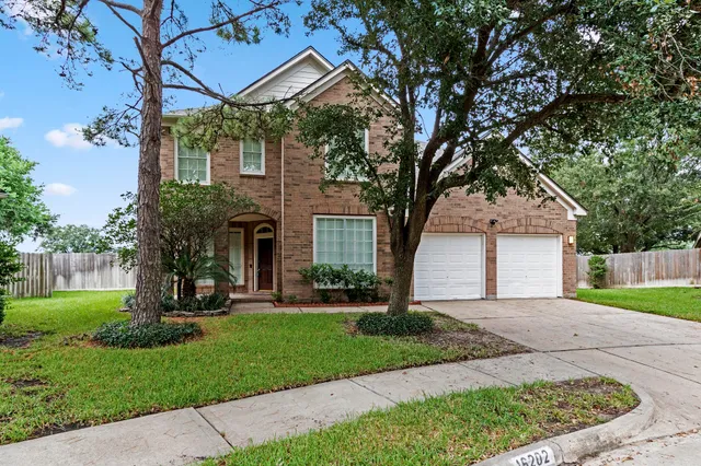 a front view of a house with a yard and tree