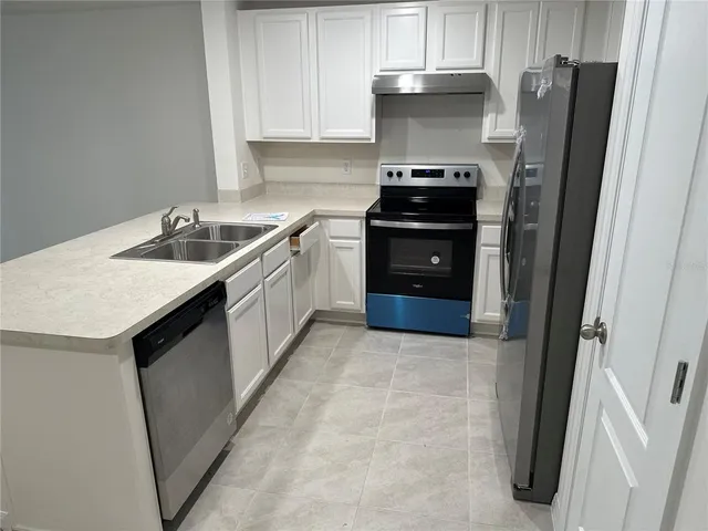 a kitchen with stainless steel appliances a stove a refrigerator and a sink