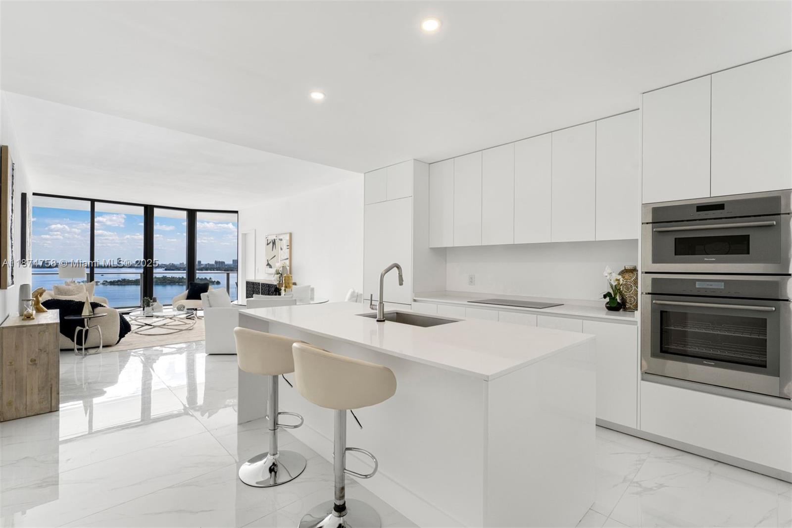 700 Northeast 24th Street, Unit 1005 Miami, FL 33137 - Photo 4 of 18 a kitchen with stainless steel appliances a stove a sink a oven a dining table and chairs