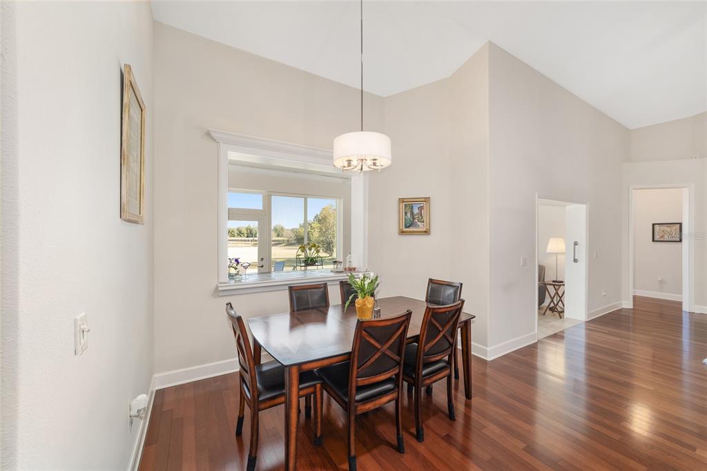 8942 Southwest 8th Street Ocala, FL 34481 - Photo 19 of 59 a dining room with furniture a chandelier and wooden floor