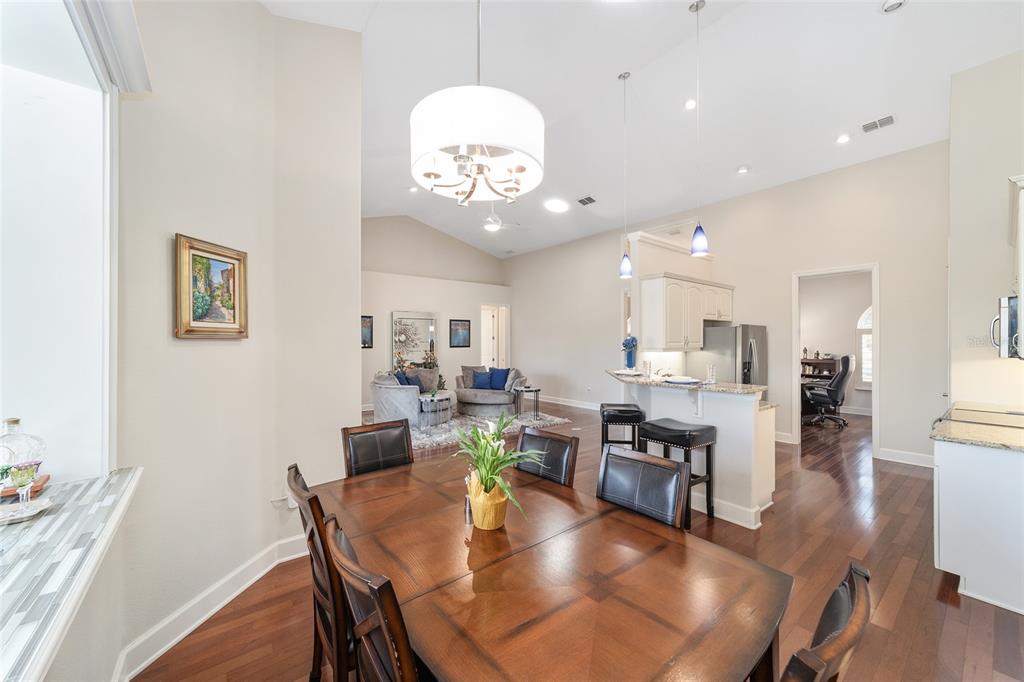 8942 Southwest 8th Street Ocala, FL 34481 - Photo 20 of 59 a view of a dining room and livingroom with furniture wooden floor a rug a fireplace and a chandelier