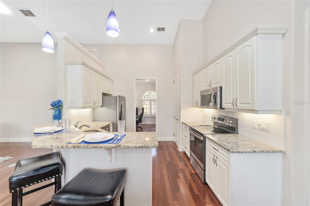 8942 Southwest 8th Street Ocala, FL 34481 - Photo 23 of 59 a kitchen with a table chairs stove and cabinets