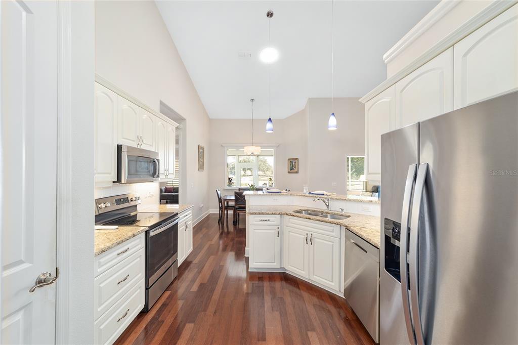8942 Southwest 8th Street Ocala, FL 34481 - Photo 25 of 59 a kitchen with white cabinets and stainless steel appliances