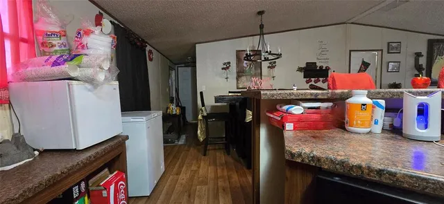 a kitchen with granite countertop lots of clutter and stainless steel appliances
