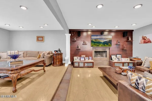 a kitchen with stainless steel appliances granite countertop sink a refrigerator a stove a dining table and chairs with wooden floor