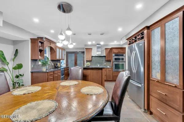 a kitchen with stainless steel appliances granite countertop a refrigerator a sink a stove and island