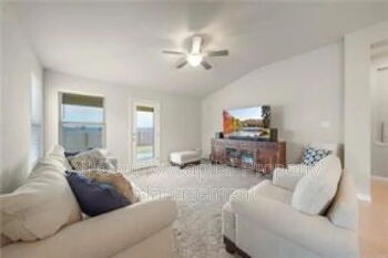 12313 Caldera Way Manor, TX 78653 - Photo 6 of 11 Spacious living area featuring light-toned walls, a ceiling fan, and carpeted flooring