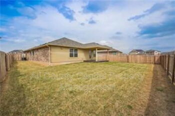 12313 Caldera Way Manor, TX 78653 - Photo 10 of 11 Fenced backyard featuring a covered patio, a grassy area, and a wood privacy fence