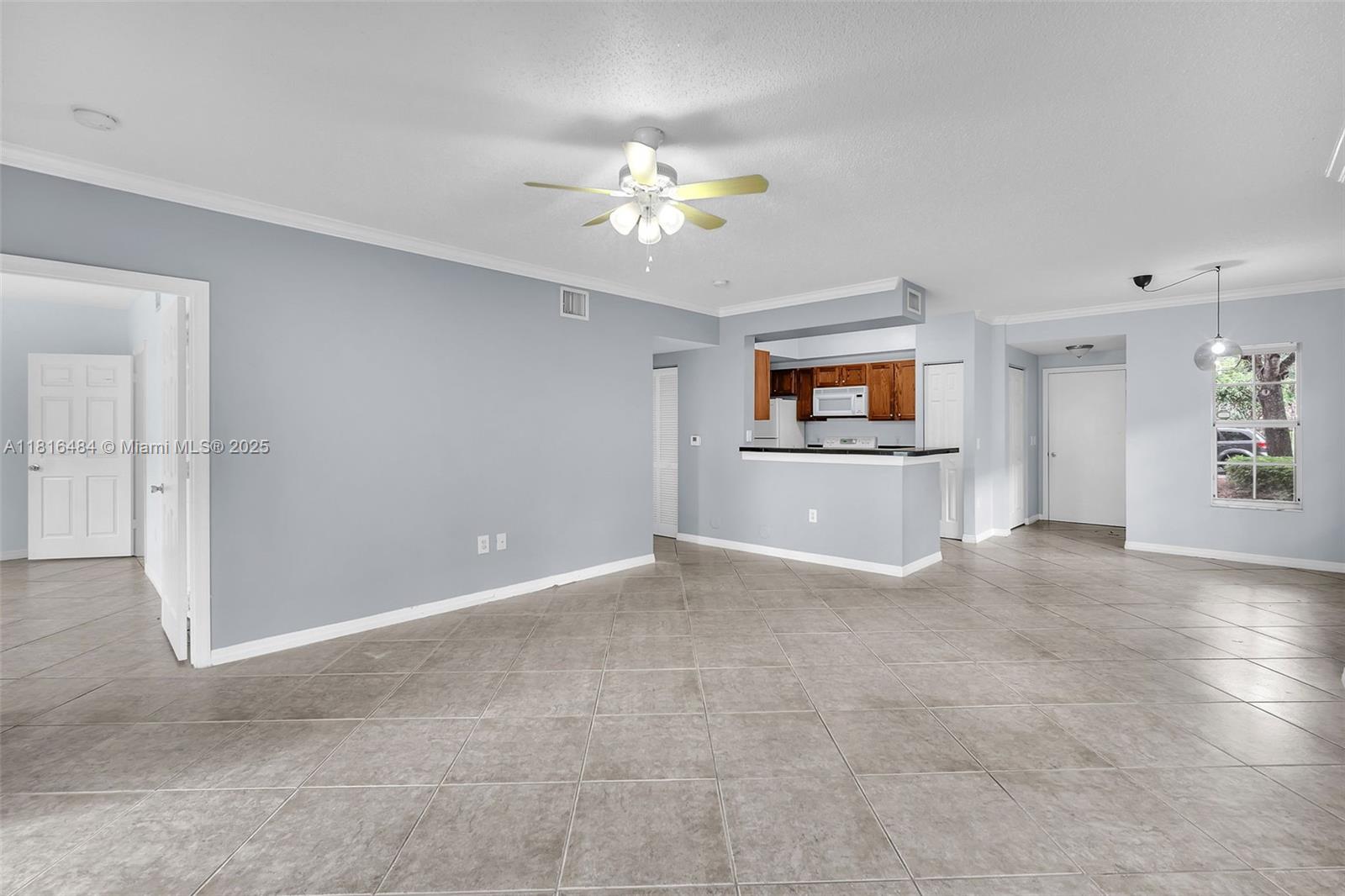 2474 Centergate Drive, Unit 101 Miramar, FL 33025 - Photo 11 of 28 an empty room with windows and chandelier fan