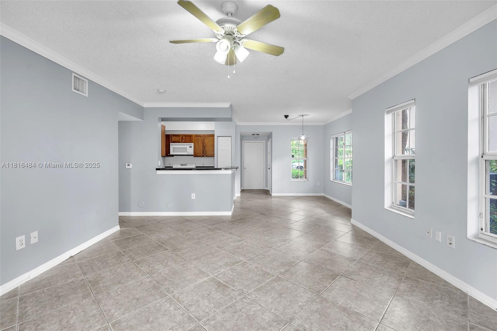 2474 Centergate Drive, Unit 101 Miramar, FL 33025 - Photo 12 of 28 a view of a big room with windows and chandelier fan