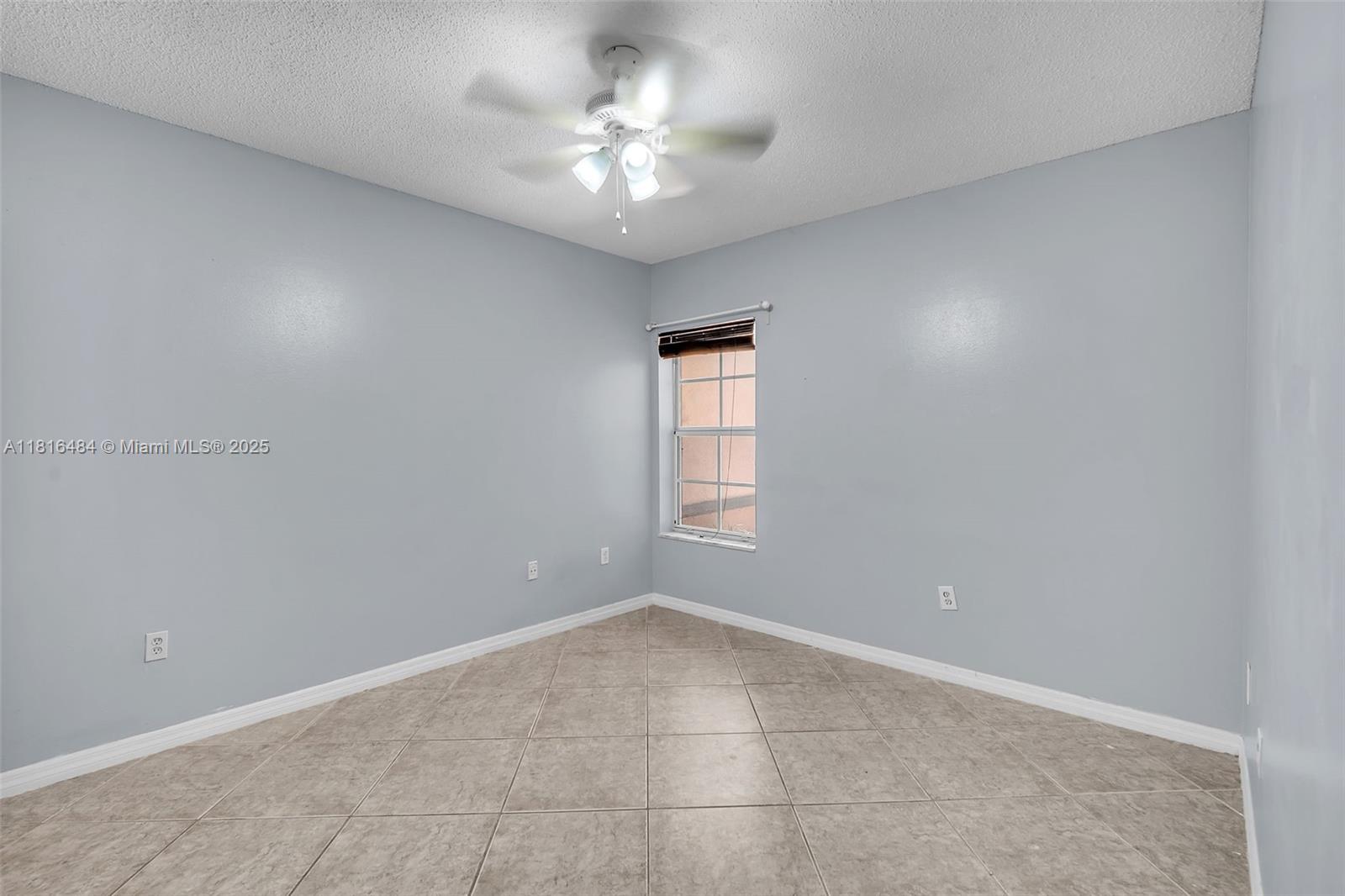 2474 Centergate Drive, Unit 101 Miramar, FL 33025 - Photo 13 of 28 an empty room with a chandelier fan and windows