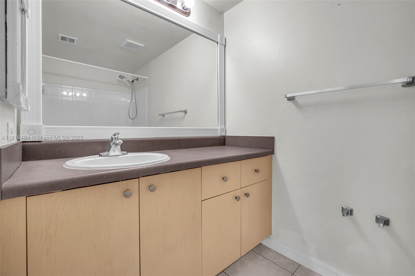 2474 Centergate Drive, Unit 101 Miramar, FL 33025 - Photo 16 of 28 a bathroom with a granite countertop sink and a mirror