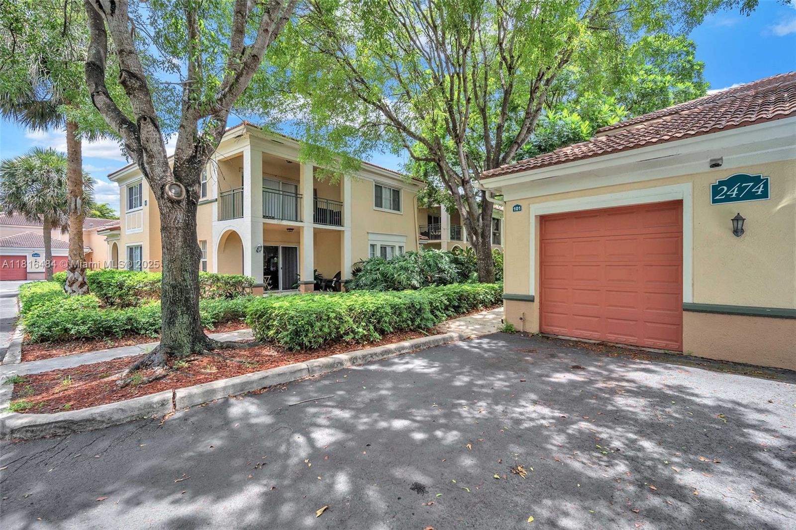 2474 Centergate Drive, Unit 101 Miramar, FL 33025 - Photo 27 of 28 a front view of a house with a garden