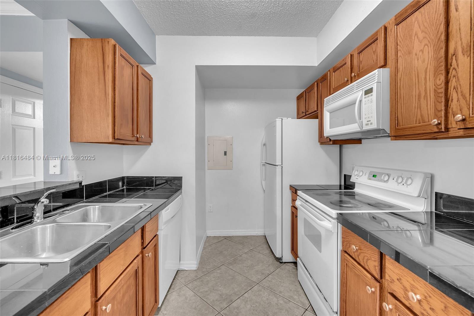 2474 Centergate Drive, Unit 101 Miramar, FL 33025 - Photo 7 of 28 a kitchen with stainless steel appliances granite countertop a sink stove and refrigerator