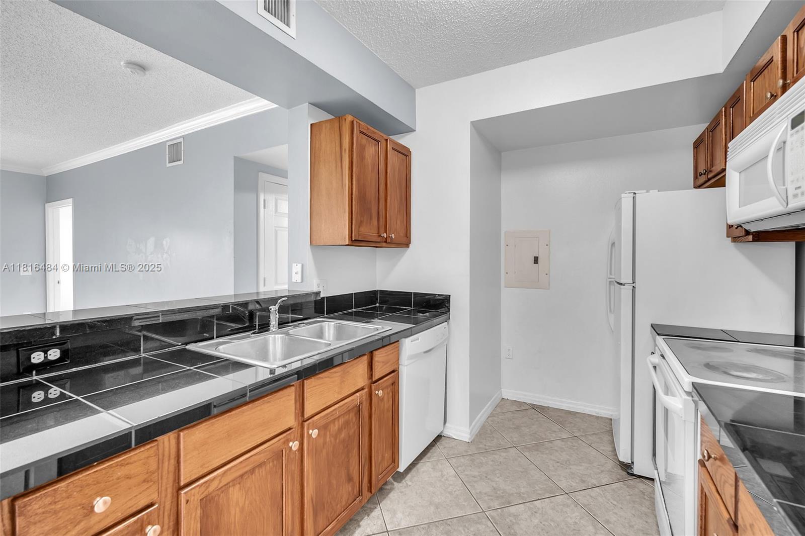 2474 Centergate Drive, Unit 101 Miramar, FL 33025 - Photo 8 of 28 a kitchen with granite countertop a sink and a stove top oven