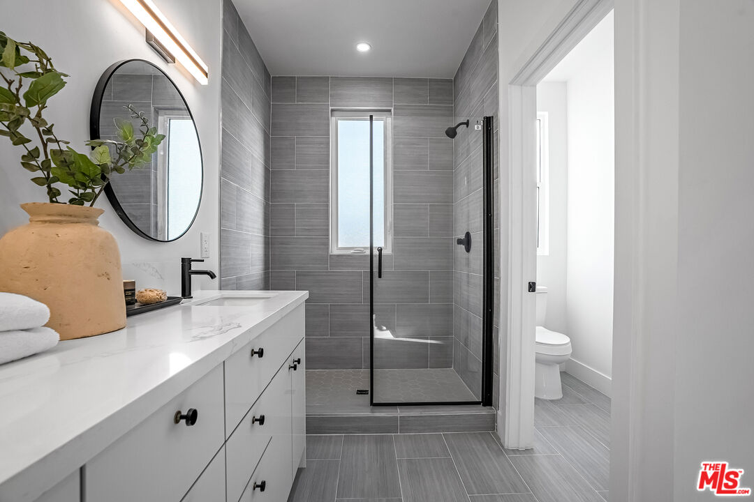 5830 David Avenue Los Angeles, CA 90034 - Photo 34 of 46 a bathroom with a toilet a sink a mirror and a shower