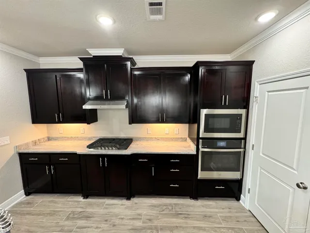 a kitchen with granite countertop stainless steel appliances and wooden cabinets