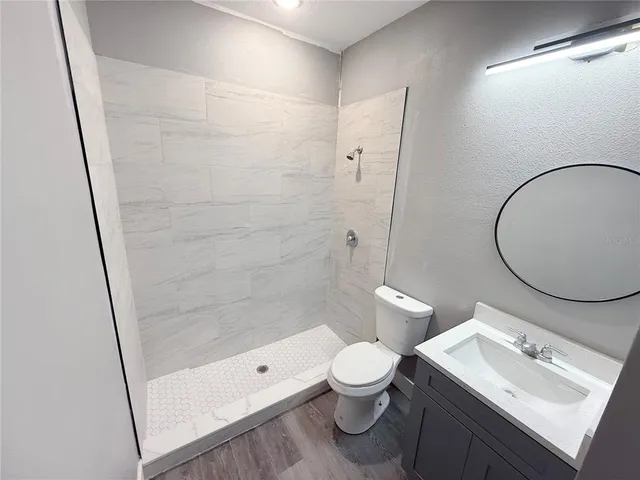 a bathroom with a sink a toilet and shower