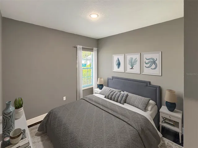 a bedroom with a bed and painting on the wall