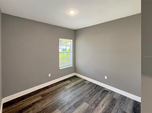 a view of room with window and wooden floor