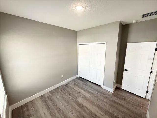 an empty room with wooden floor and door