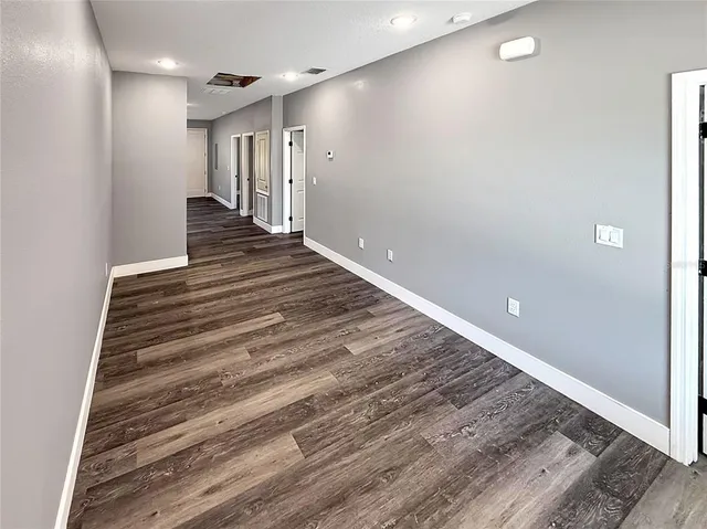 a view of a hallway with stairs and a wooden floor