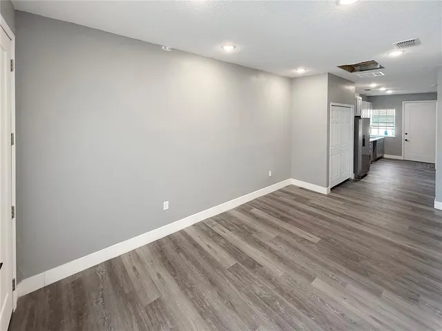a view of empty room with wooden floor
