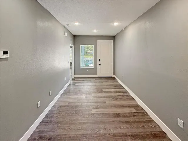 a view of an empty room with wooden floor