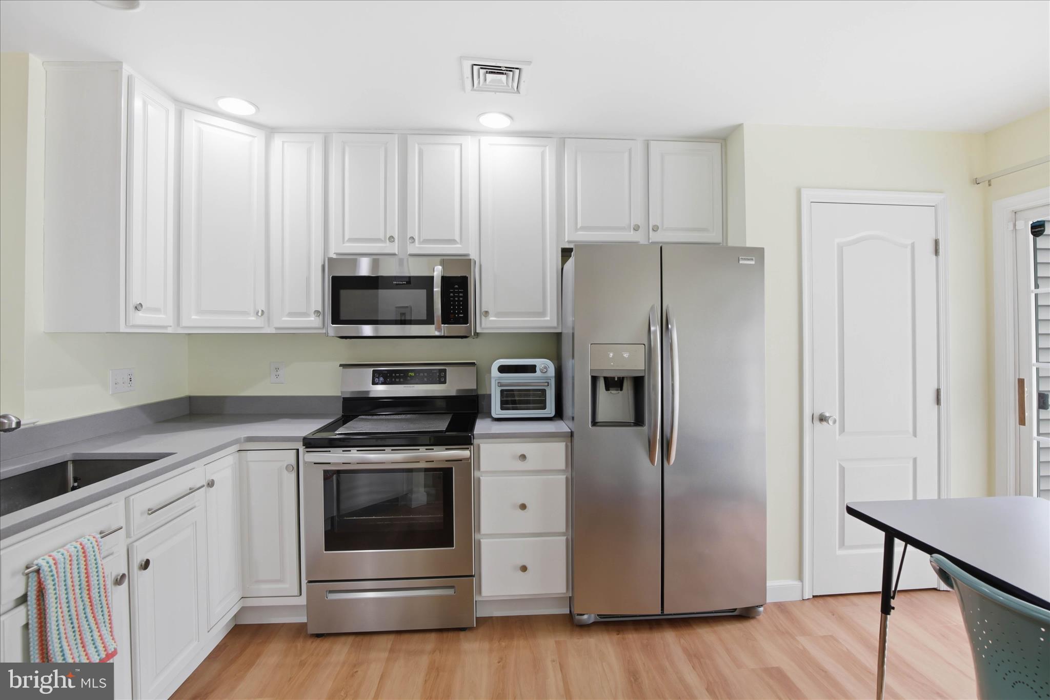 52 Coopers Way Denver, PA 17517 - Photo 9 of 29 a kitchen with cabinets stainless steel appliances and wooden floor