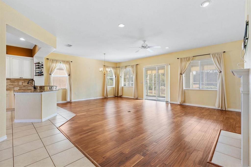 13655 Southeast 97th Terrace Road Summerfield, FL 34491 - Photo 12 of 49 a view of an empty room with wooden floor and a kitchen
