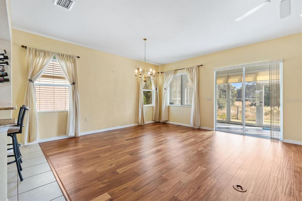 13655 Southeast 97th Terrace Road Summerfield, FL 34491 - Photo 13 of 49 a view of an empty room with glass door and wooden floor