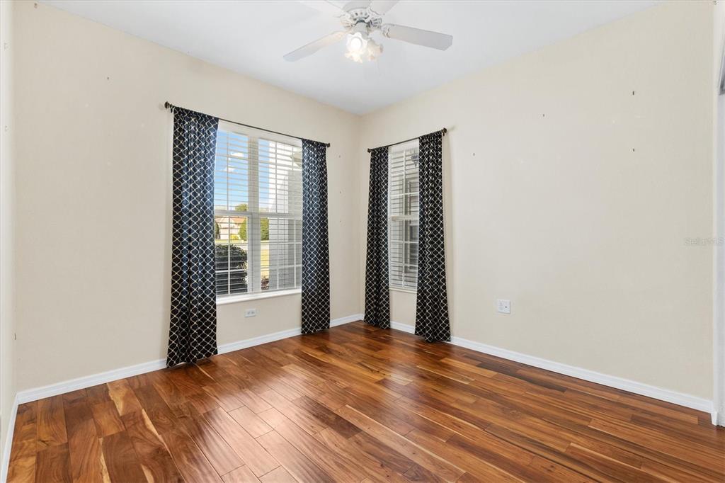 13655 Southeast 97th Terrace Road Summerfield, FL 34491 - Photo 27 of 49 a view of a bedroom with wooden floor and a ceiling fan