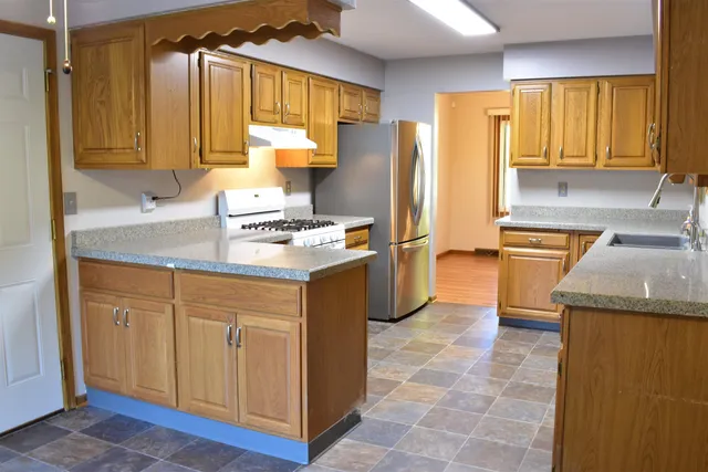 a kitchen with stainless steel appliances granite countertop a sink cabinets and a window