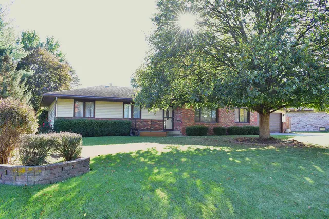 a front view of a house with a yard and trees