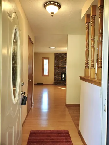 a view of a hallway with wooden floor and windows