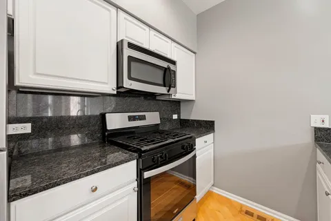 a kitchen with stainless steel appliances granite countertop a sink stove and microwave