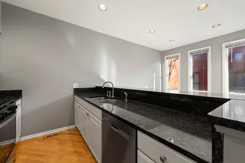 a kitchen with granite countertop a sink and cabinets