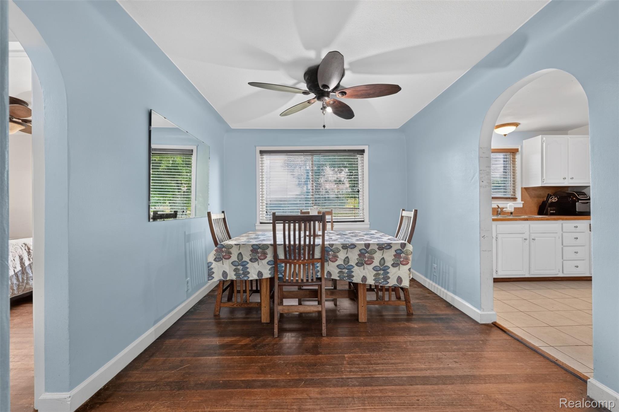 7369 North Webster Road Mount Morris, MI 48458 - Photo 16 of 56 Hardwood flooring, arched doorways, ceiling fan with integrated lighting, and multiple windows with blinds