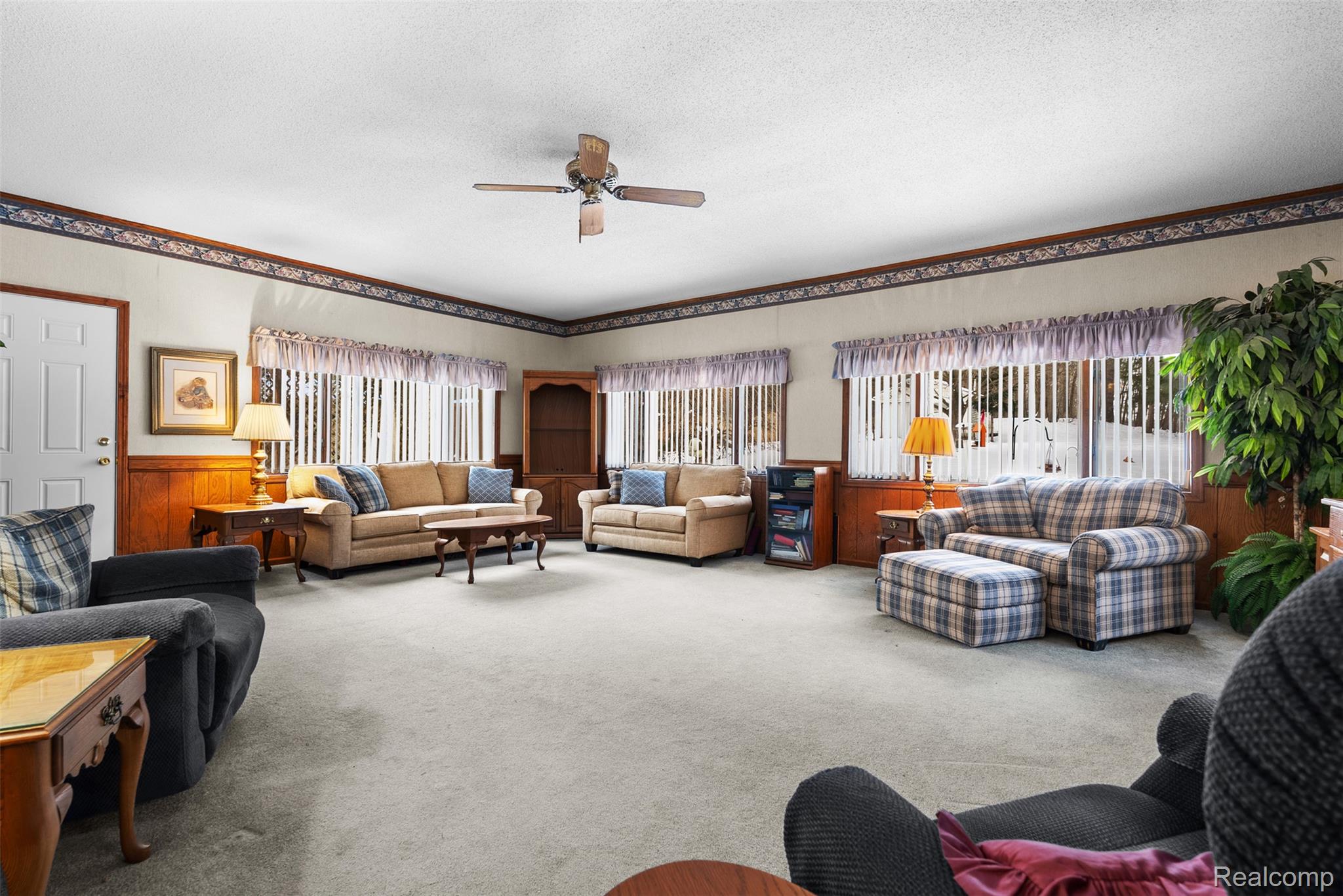 7192 Torrey Road Swartz Creek, MI 48473 - Photo 12 of 27 Living room featuring a wainscoted wall, carpet floors, a ceiling fan, wood walls, and a textured ceiling