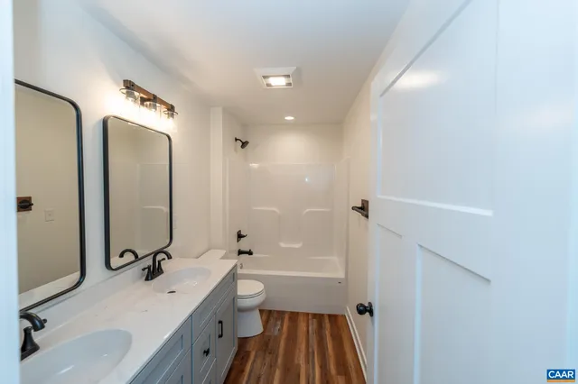 a bathroom with a double vanity sink double mirror bathtub and shower
