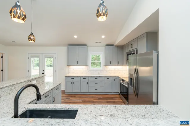 a kitchen with stainless steel appliances granite countertop a sink a refrigerator and a granite counter tops